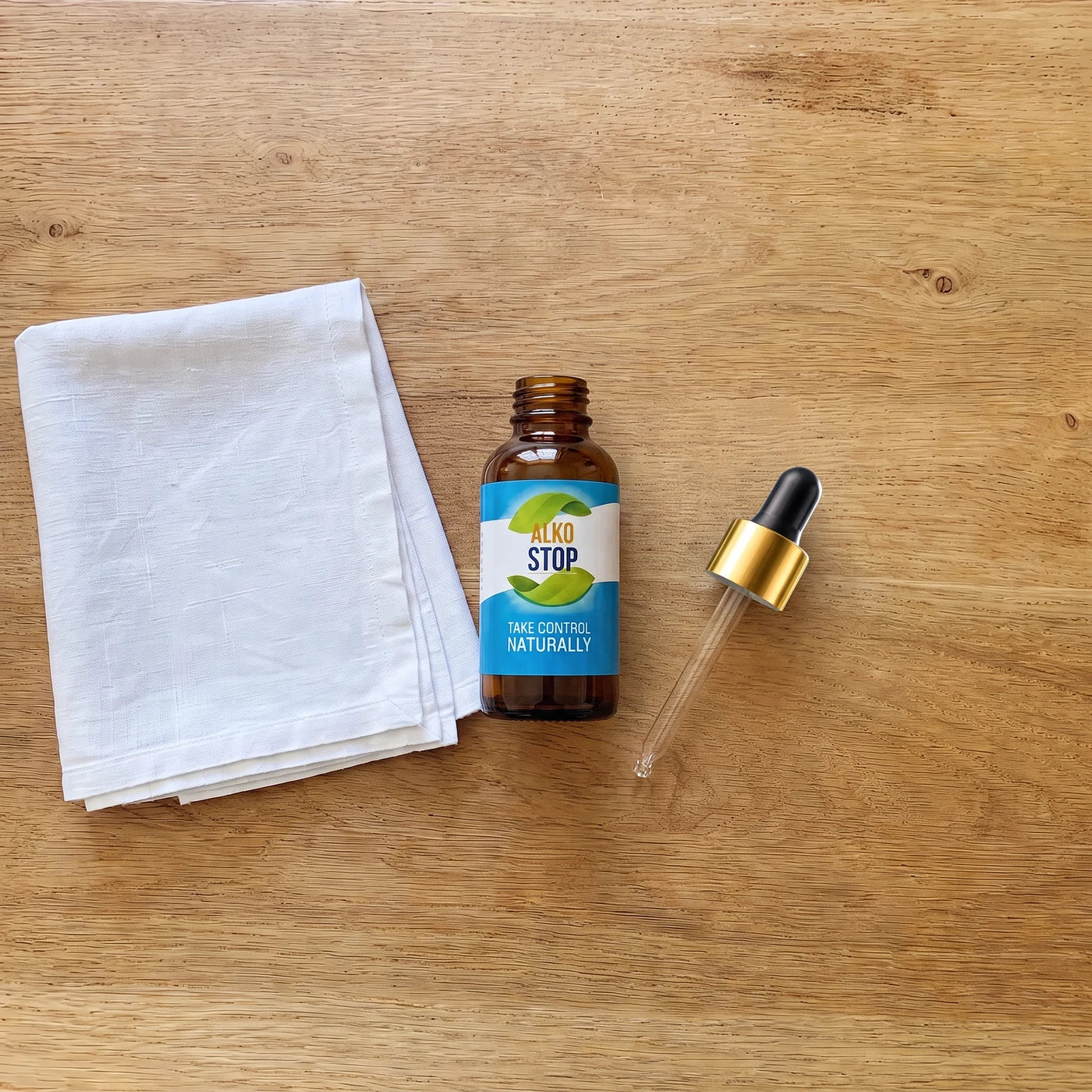 AlkoStop dropper bottle, open, resting on a folded white linen cloth