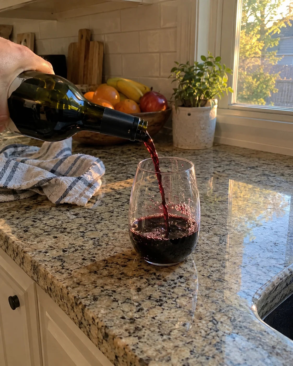 Wine being poured into a glass on a kitchen counter at 5pm