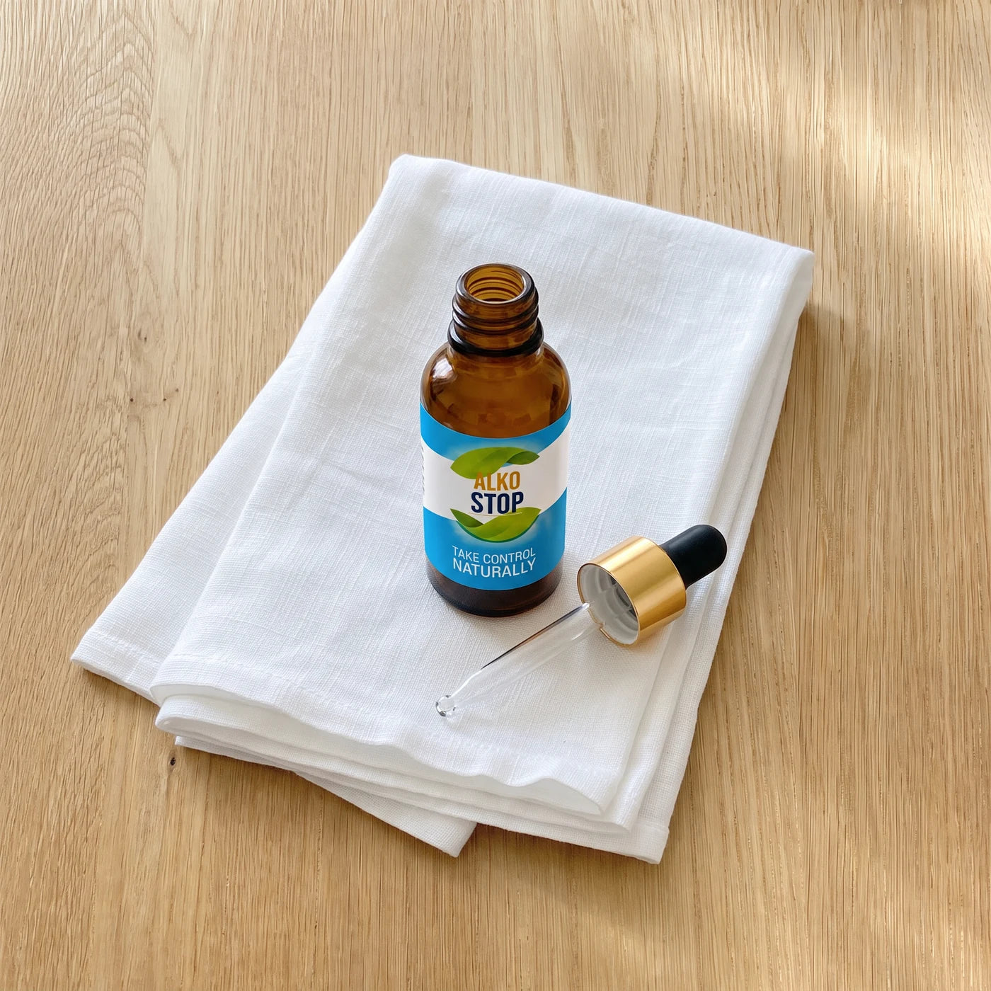 AlkoStop dropper bottle resting on a folded white linen cloth