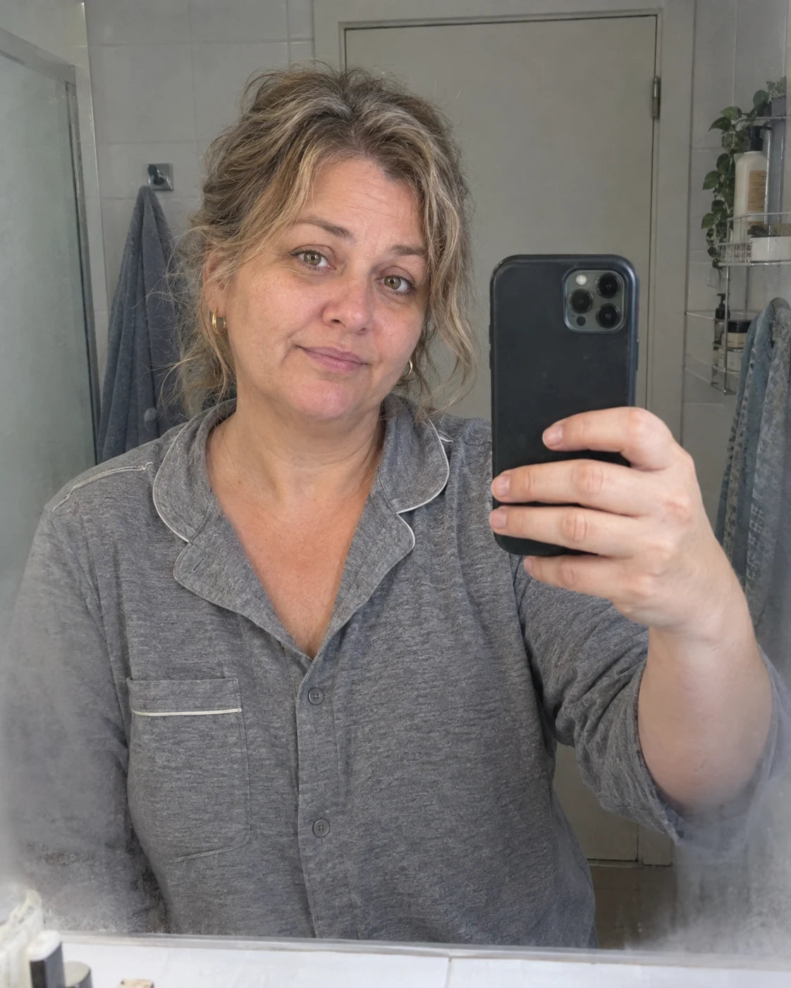 Woman's handheld selfie in a bathroom mirror in the morning