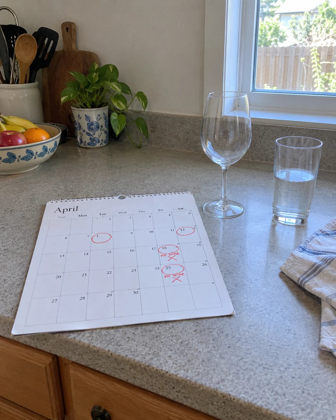 Kitchen calendar with days circled and 'no wine' crossed out, next to an empty wine glass