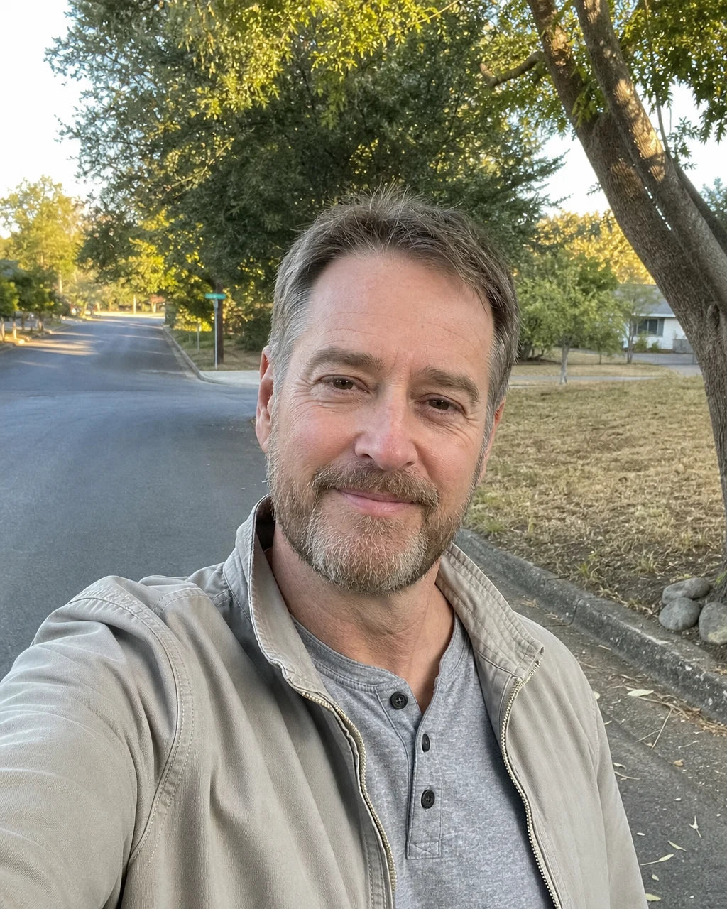 A man smiling and relaxed on an outdoor morning walk
