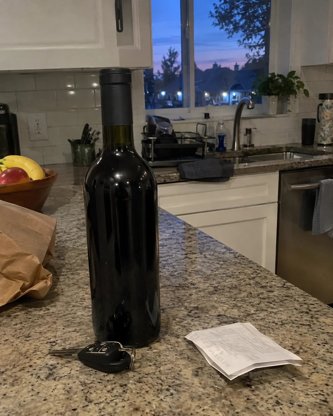 Untouched wine bottle on a kitchen counter at dusk